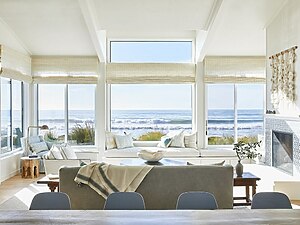 ​A Coastal Grandma Style Home living room featuring luxury sofas, solid wood center tables, and wooden side tables.