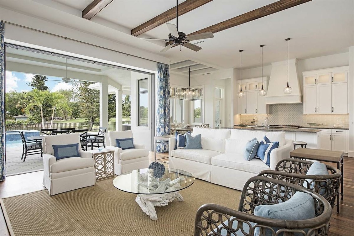 Coastal Grandma Style Home living room featuring a harmonious blend of white and blue tones, a sturdy wooden center table, and robust armchairs and sofas