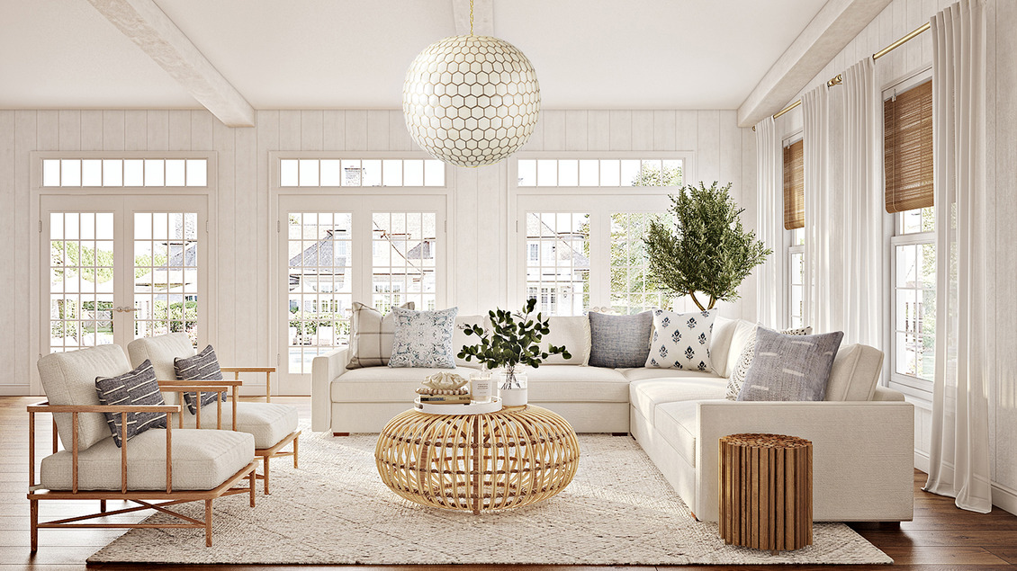 Living room in a Coastal Grandma Style Home featuring neutral tones, light fabrics, a round rattan coffee table, and two wood armchairs.