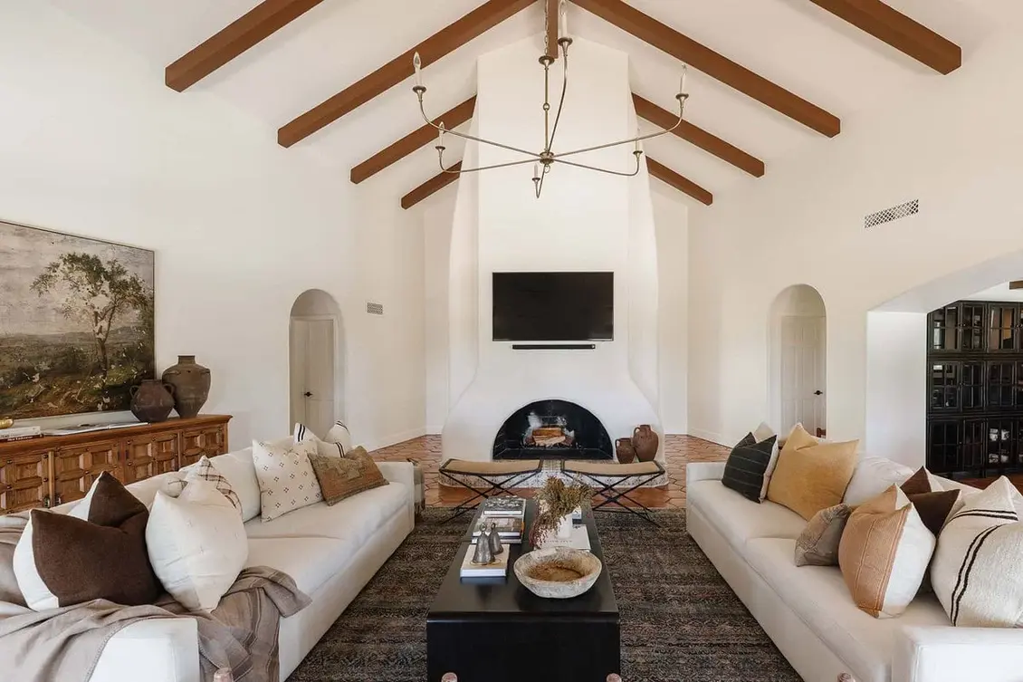 Spanish Colonial Interior living room with earthy tones, featuring brown sofas and cushions, highlighting traditional design elements.