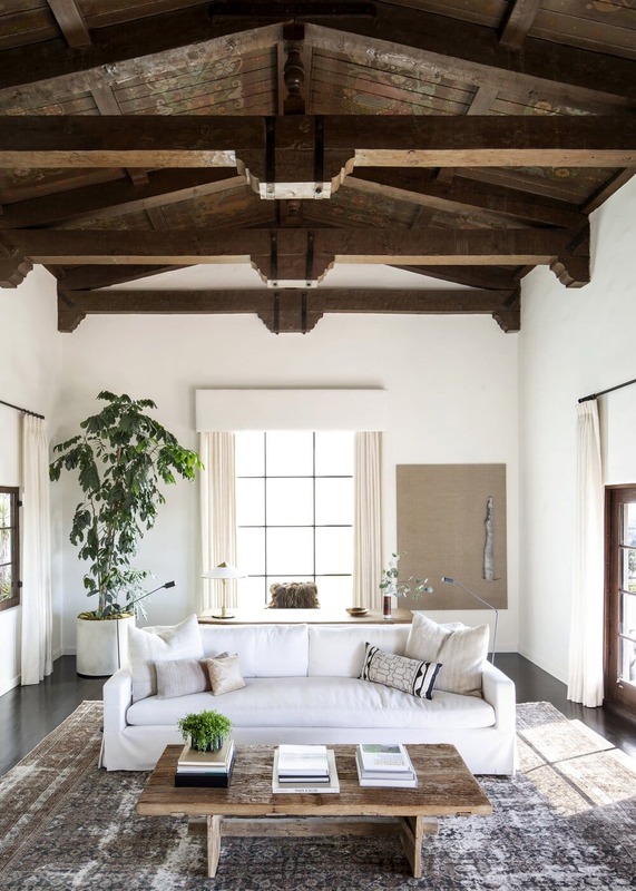 Spanish Colonial Interior living room with raw wood coffee table and white sofa, combining natural textures for a cozy atmosphere.