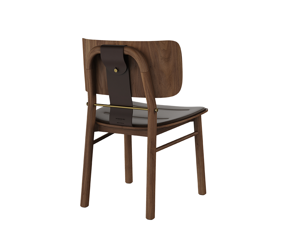 Back three-quarter view of the Arthur Dining Chair in dark walnut wood, highlighting the dark brown leather upholstered seat, curved wooden backrest, dark saddle leather back strap, and aged brushed brass bar and button detail.