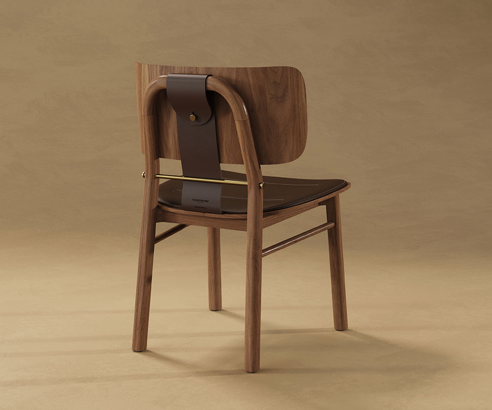 Studio shot from behind the Arthur Dining Chair in dark walnut, focusing on the craftsmanship of the leather strap, brass bar, and wooden frame.