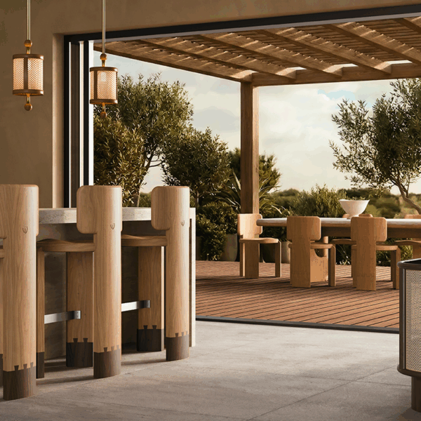 Modern luxury outdoor patio dining area featuring the Benjamin Dining Chair and Portman Dining Table on a wooden deck. Inside, three wooden Benjamin Bar Chairs sit at a stone bar counter under Hamilton Pendant Lamps. A Wodehouse Sideboard decorated with a Hamilton Table Lamp completes the warm, minimalist indoor-outdoor setting.