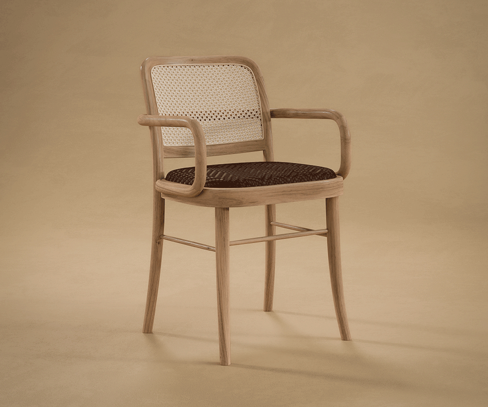 Three-quarter front view of the Charles II Dining Chair by Wood Tailors Club in light natural wood, featuring a woven rattan backrest, curved armrests, and a dark and light upholstered braided leather seat, in a warm background.