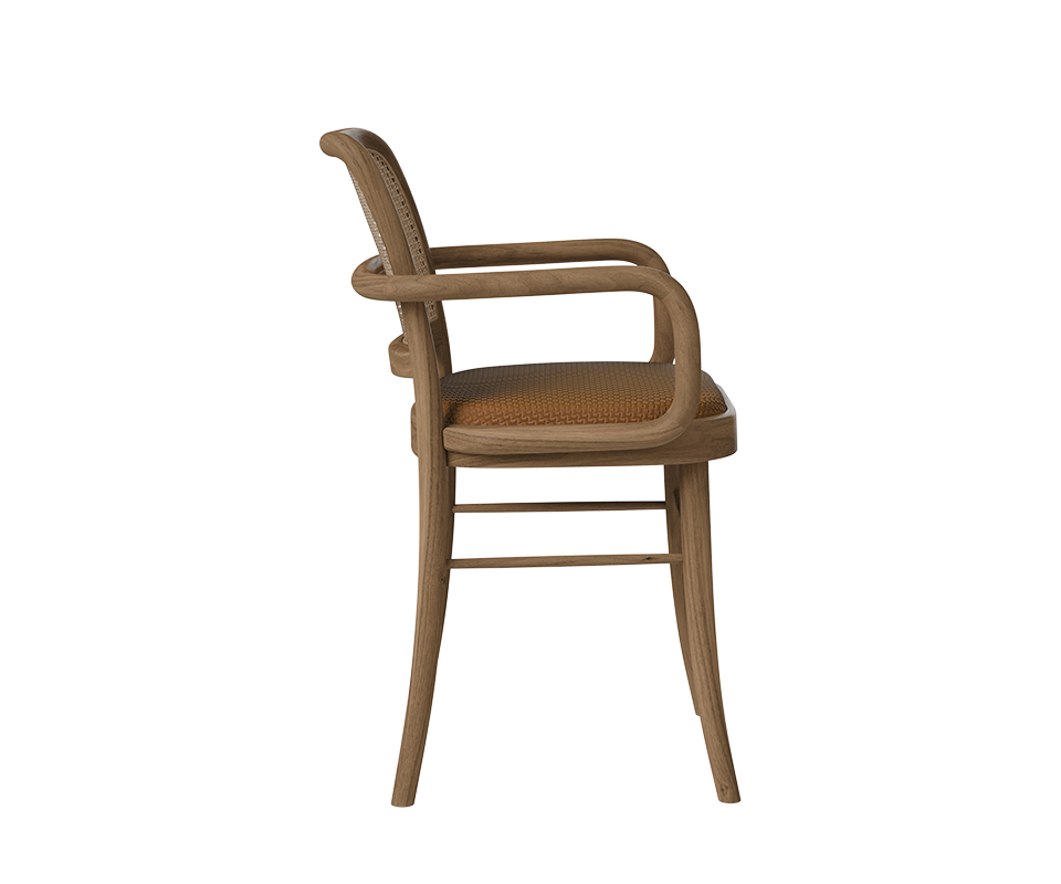 Side profile view of the Charles II Dining Chair by Wood Tailors Club highlighting the ergonomic curve of the wooden frame, cane backrest, and cognac braided leather seat cushion.