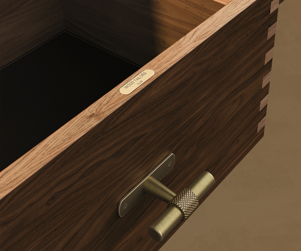 Close-up view looking into an open walnut drawer of the Edward Sideboard, highlighting its dark leather lining, dovetail corner joints, T-bar brass handle, and an engraved "Wood Tailors Club" brass plaque along the top edge.