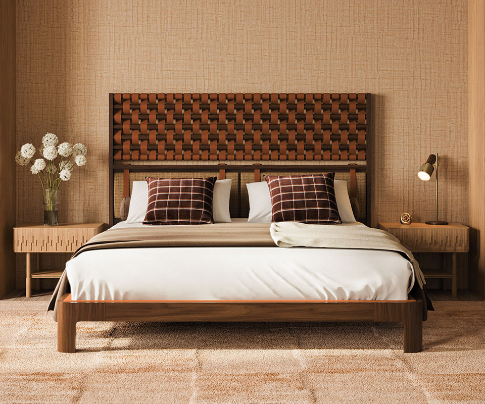 Herschel Table Lamp Herschel table lamp in smoked walnut wood and aged brushed brass paired with a Campbell bedside table in oak wood. O'Connell II Bed with a headboard featuring leather details in Prestige fabric from Élitis, set in a bedroom with Élitis Abaca wallpaper and Ralph Lauren Wallace throw pillows.