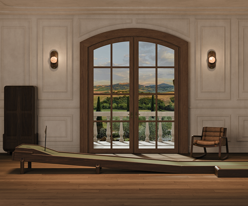Kennedy Golf Locker An interior lifestyle scene showing the Sutherland Mini Golf set placed in a luxury room with classic wall moldings and large arched French doors overlooking a scenic landscape.