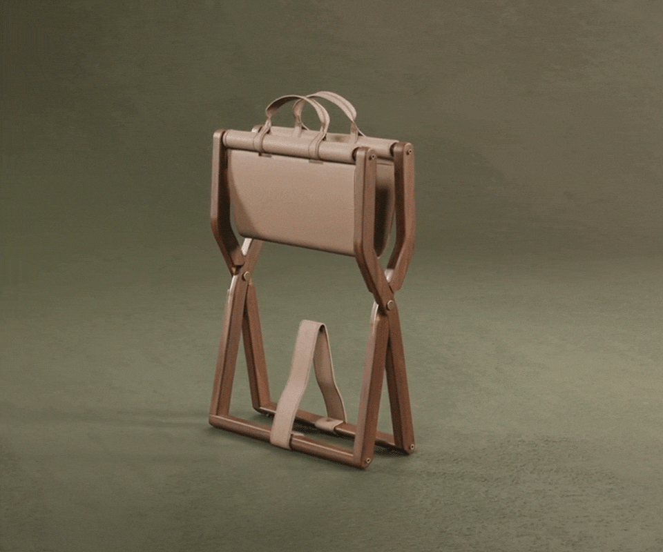 Angled view of the Korda stool demonstrating its portability and the functional leather carry handles at the top.