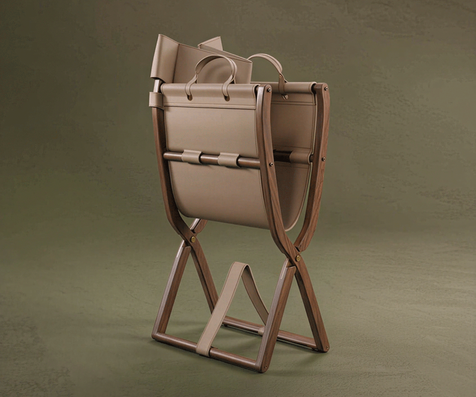 Korda Folding Chair, director's chair, by Wood Tailors Club shown in a studio setting. This luxury furniture piece features a sculpted wooden frame, beige leather seat and backrest, and high-end detailing. the chair's versatile design suitable for executive offices or sophisticated outdoor spaces.
