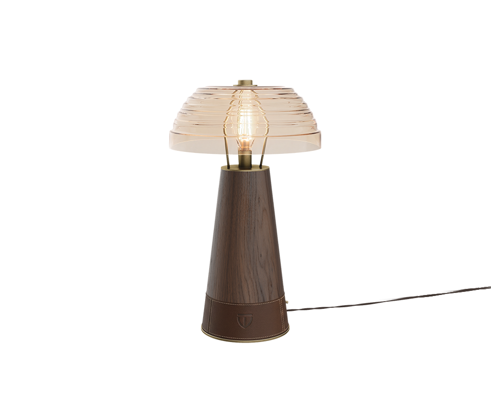 Studio shot of the Lloyd Table Lamp featuring a extra clear glass dome shade. The conical base is crafted from rich smoked wood, finished at the bottom with a dark brown stitched leather wrap displaying a subtle woodtailors club emblem.