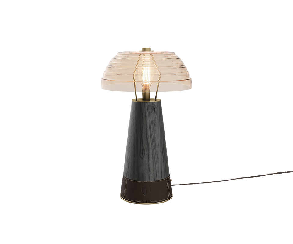 Studio shot of the Lloyd Table Lamp featuring a extra clear glass dome shade. The conical base is crafted from rich black stained wood, finished at the bottom with a dark brown stitched leather wrap displaying a subtle woodtailors club emblem.