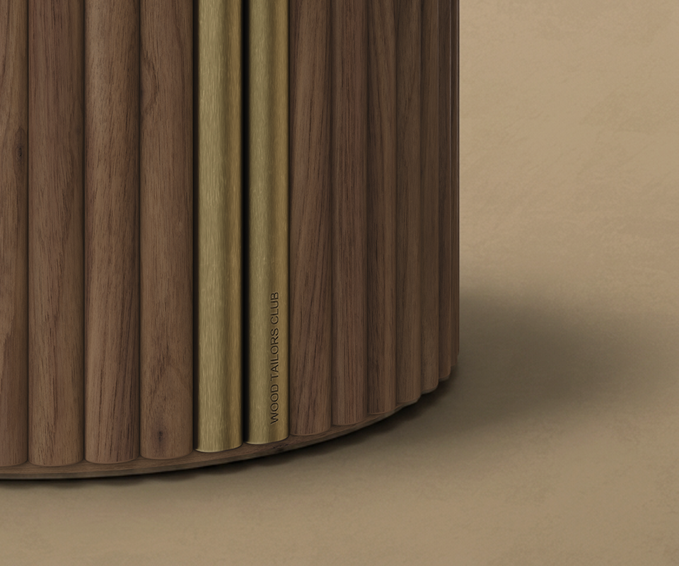 Extreme close-up shot of the Stuart I Dining Table's fluted wooden base, highlighting two vertical brushed brass metallic accents with the subtle engraved "WOOD TAILORS CLUB" branding.