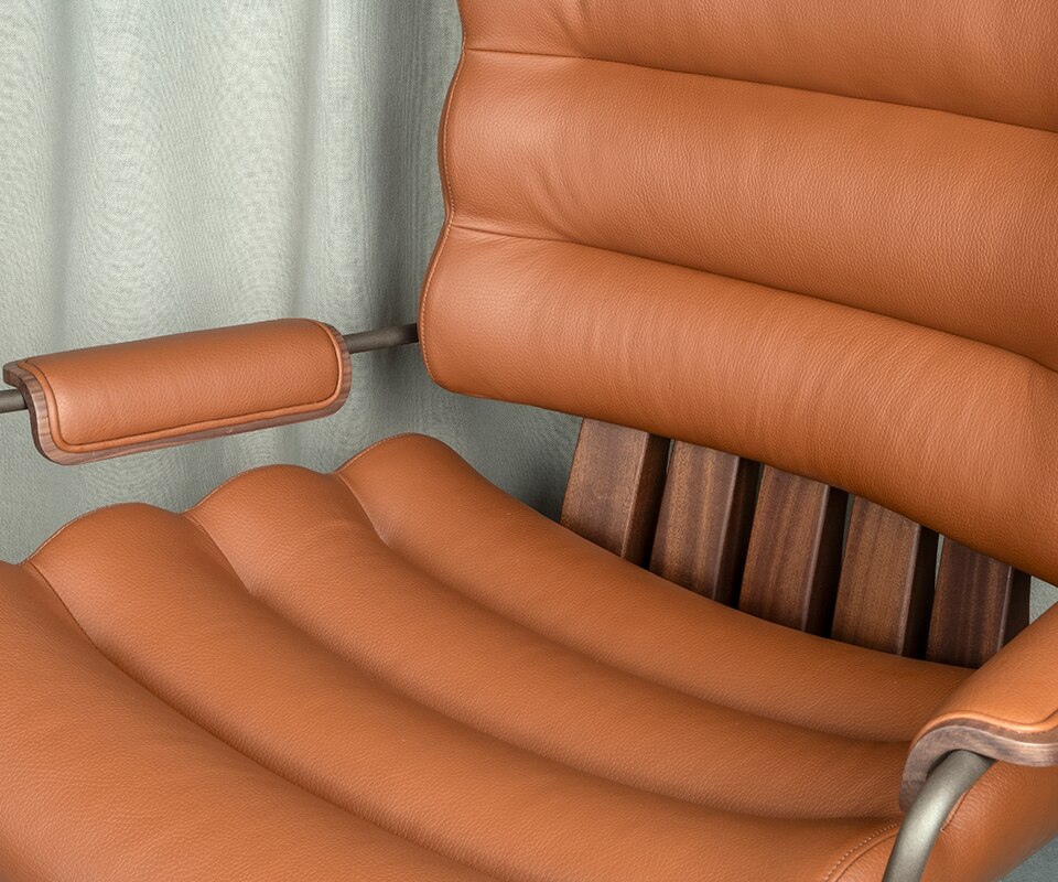 Thomas I Office Chair Close-up of the Thomas I office chair, highlighting the rich texture of orange genuine leather and the warmth of smoked walnut wood.