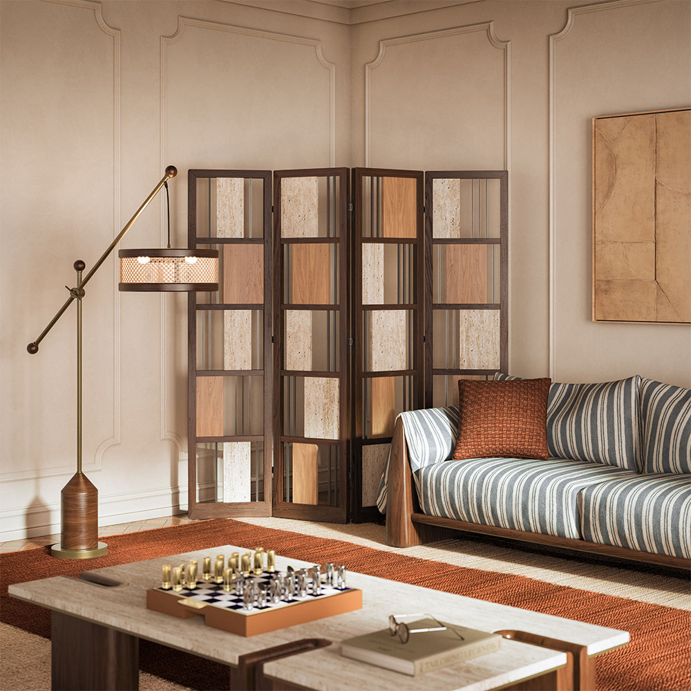 Living room interior featuring the Wordsworth folding screen in smoked walnut wood, travertine, and brass; Hamilton floor lamp in smoked walnut and brass; Dudley sofa in striped fabric; and Grenville center table. The space showcases warm tones throughout.